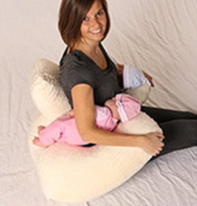 Woman using Infant Multifunctional Nursing Pillow Cushion while holding two infants in pink outfits.